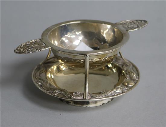 A late 19th/early 20th century Chinese Export silver tea strainer and stand by Wang Hing, Hong Kong, height 44mm.